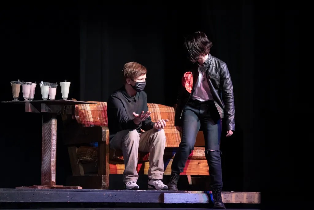 Brenton Lucas as Richard talking to Tori Beck as Charlie Manson on a couch with Ice Cream in Gillette Drama Guild and Campbell County High School's "The Fancy Hat Family"