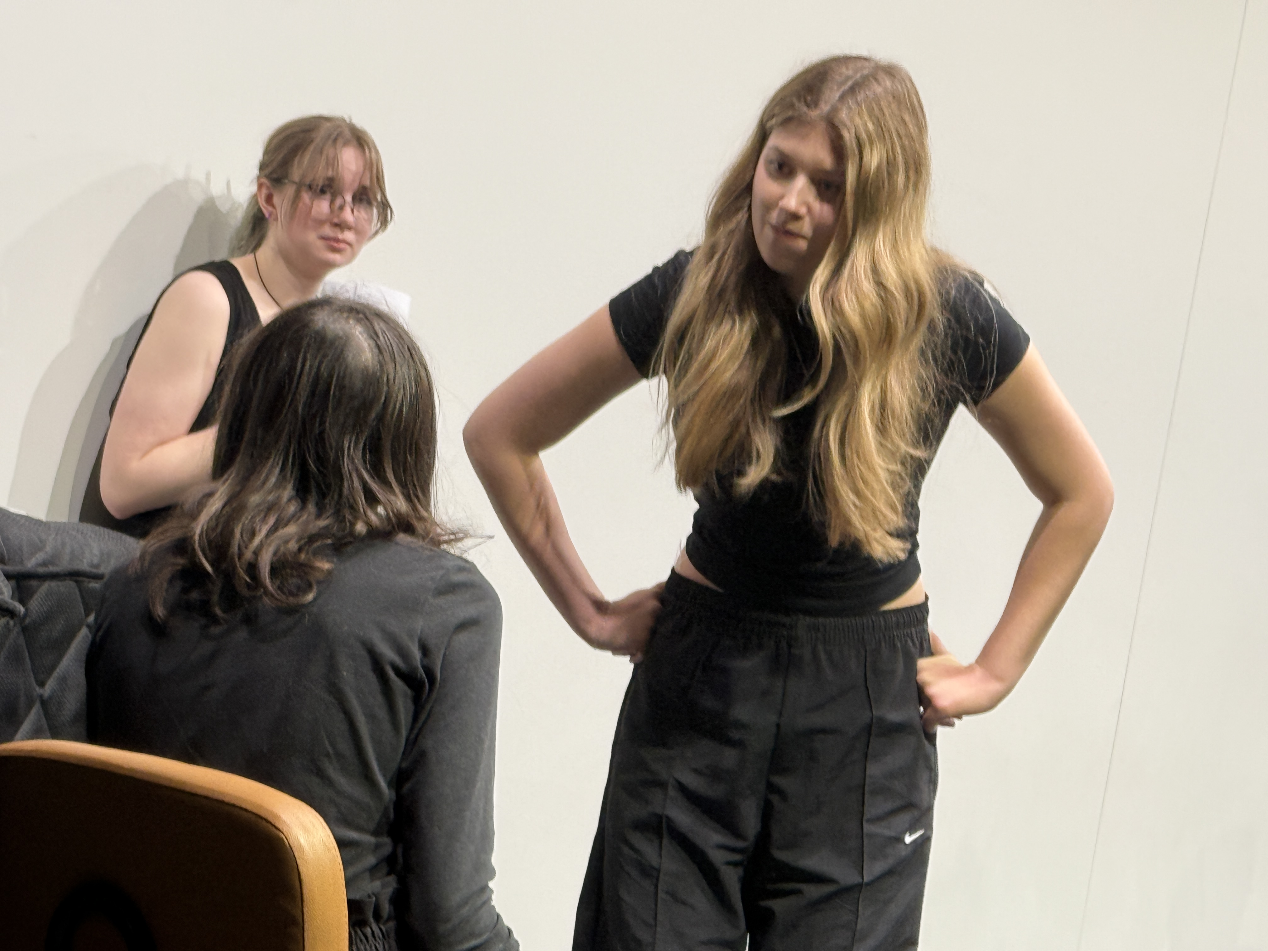 Ella Galens as Howard confronting Caitlyn Myers as Host with Veronica Thomas as PA scared in the back in "Friday Morning with the Franklins" at the Facility for Rare Isotope Beams (FRIB) produced by Second Stage Playwriting
