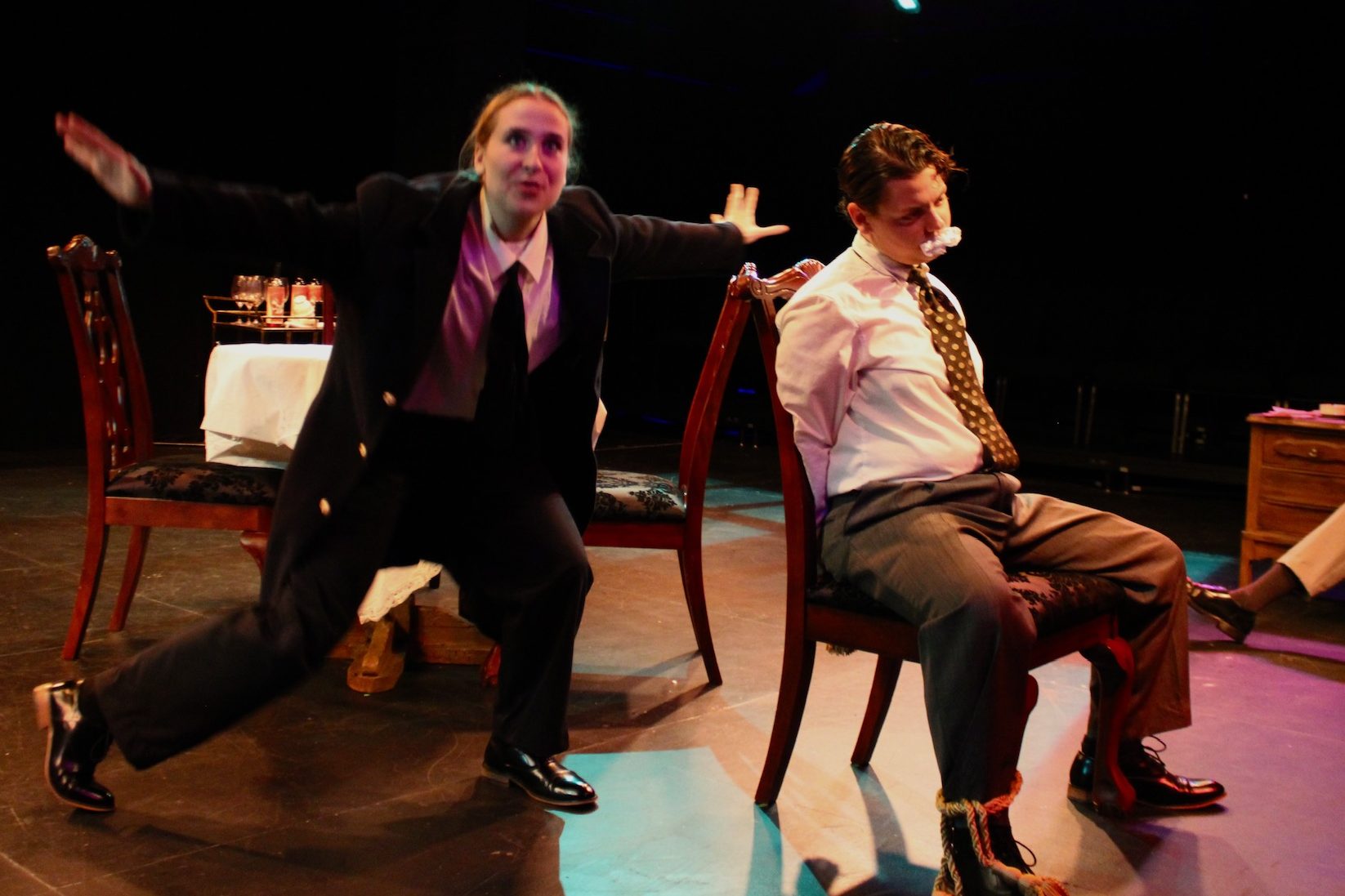 Olivia Welch as Officer O'Hara telling a story to a tied up Tobias Sanders as Mortimer Brewster in Second Stage Productions "Arsenic and Old Lace"