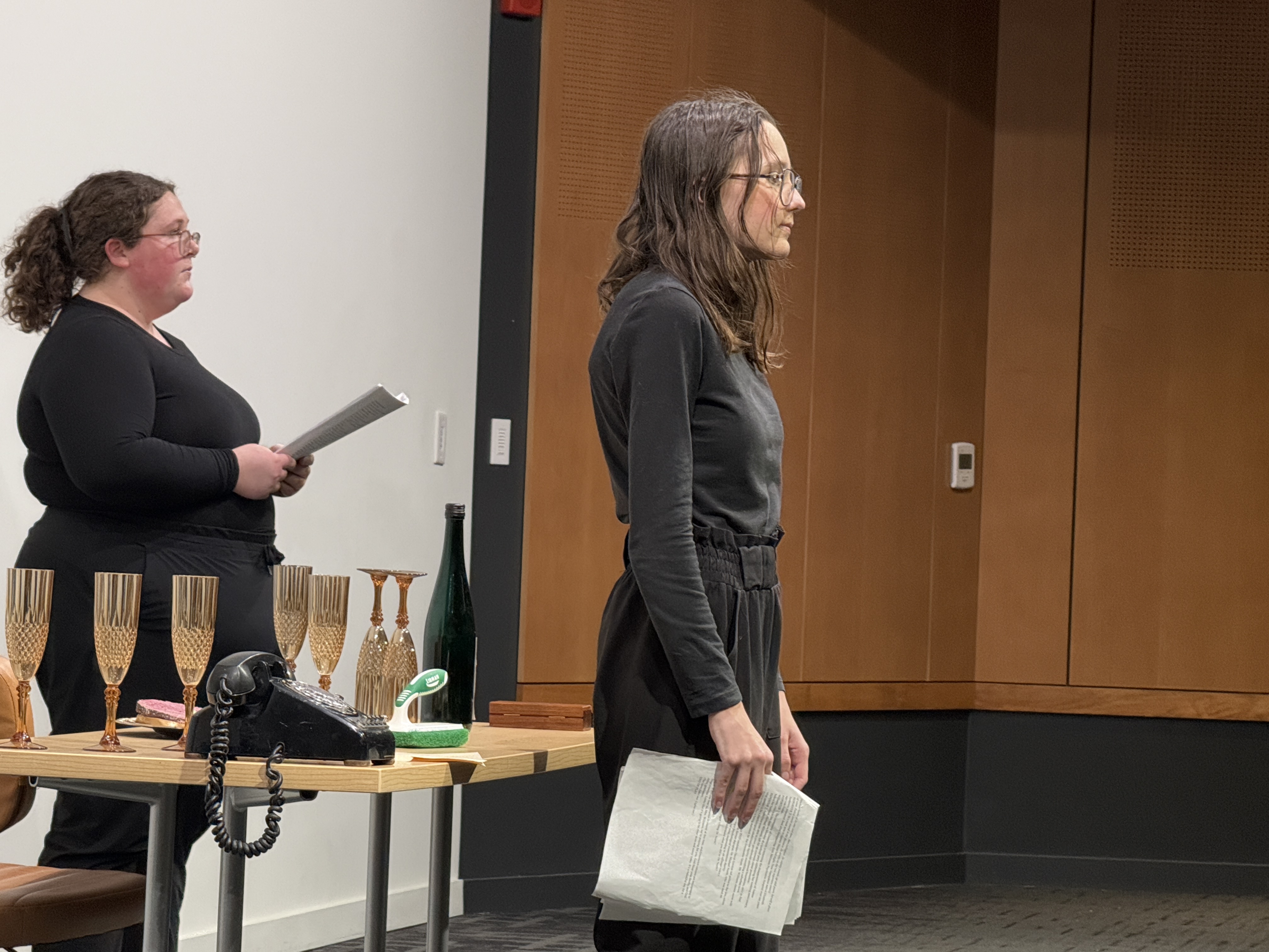 Close Up on Caitlyn Myers as Jo standing trial with Ella Galens as 1950's reporter and Reese Verlinde as a modern reporter forming a triangle in "Nuclear" at the Facility for Rare Isotope Beams (FRIB) produced by Second Stage Playwriting