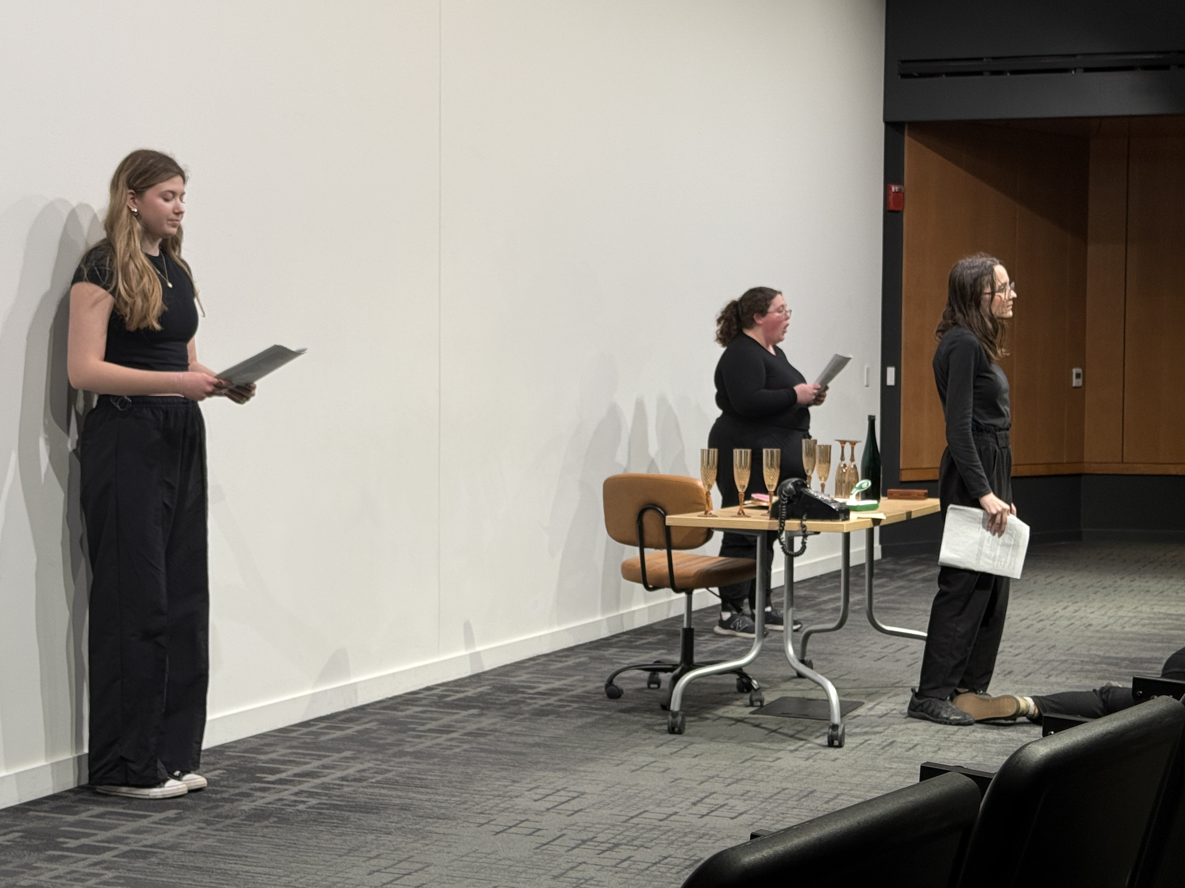 Caitlyn Myers as Jo standing trial with Ella Galens as 1950's reporter and Reese Verlinde as a modern reporter forming a triangle in "Nuclear" at the Facility for Rare Isotope Beams (FRIB) produced by Second Stage Playwriting
