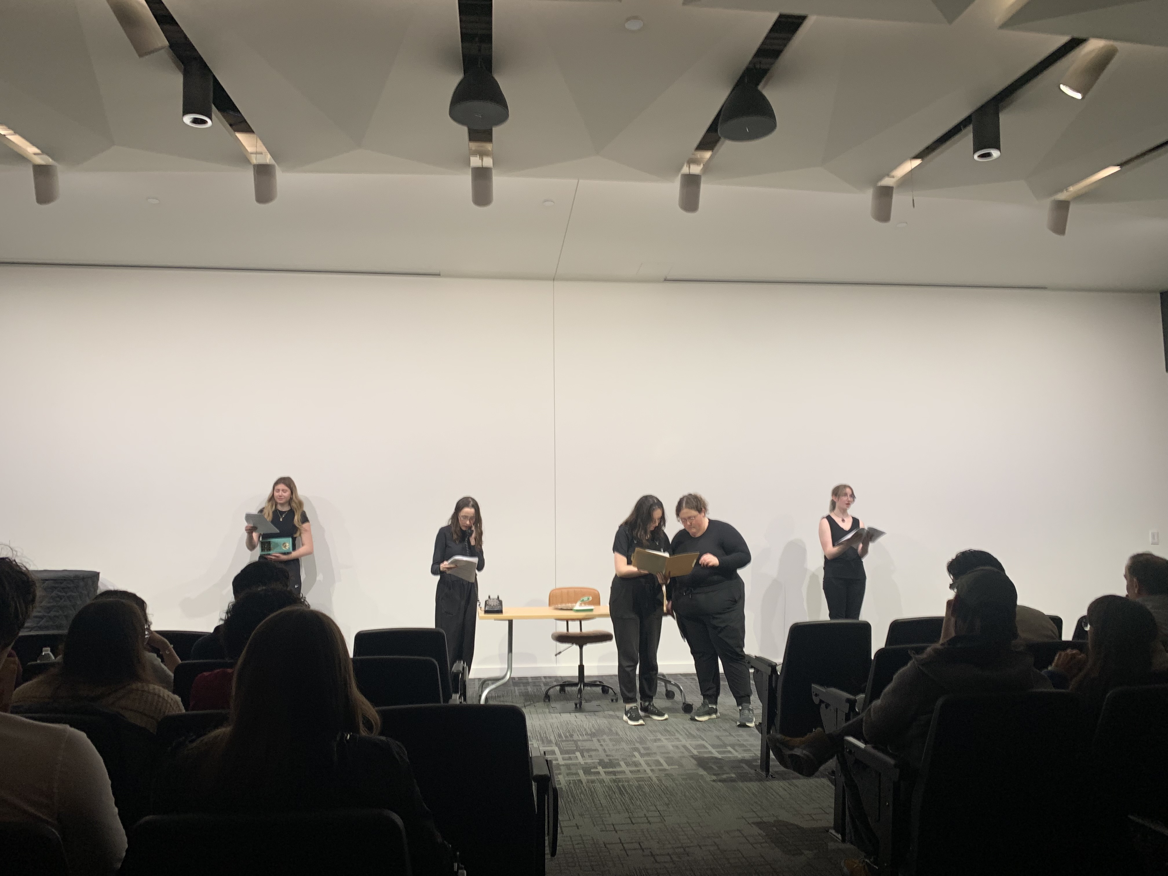 Full stage of the case file discovery in "Nuclear" at the Facility for Rare Isotope Beams (FRIB) produced by Second Stage Playwriting, featuring Ella Galens as the radio, Caitlyn Myers as Jo, Alison Mastee as Cady, Reese Verlinde as Margaret, and Veronica Thomas