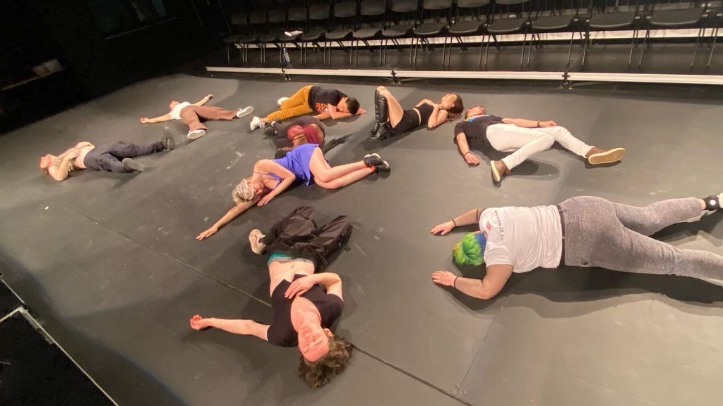Ebony Battle, Joie Culligan, Christopher Eastland, Tim Hackbarth, Henry J, Maya Joyce, Tessa Kresch, David Meagher, and Sam Smelser laying on the floor of MSU Studio 60 as part of "Precious Winners All: Shakespeare Shooketh Up"