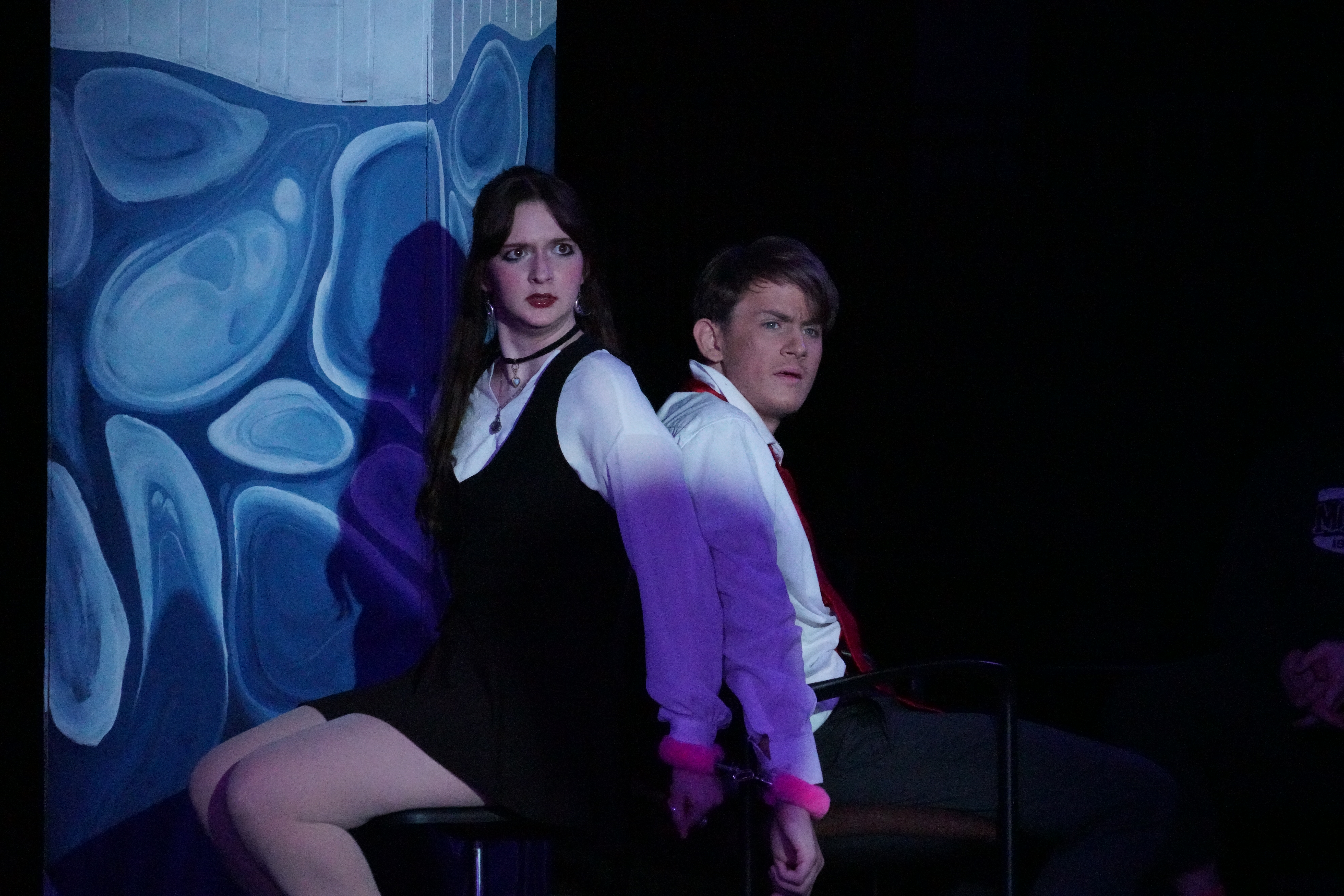 Evan Niemiec as Ted and Brooke Cousins as Emma tied up in Hidgen's lab by pink handcuffs in Second Stage Productions "The Guy Who Didn't Like Musicals"