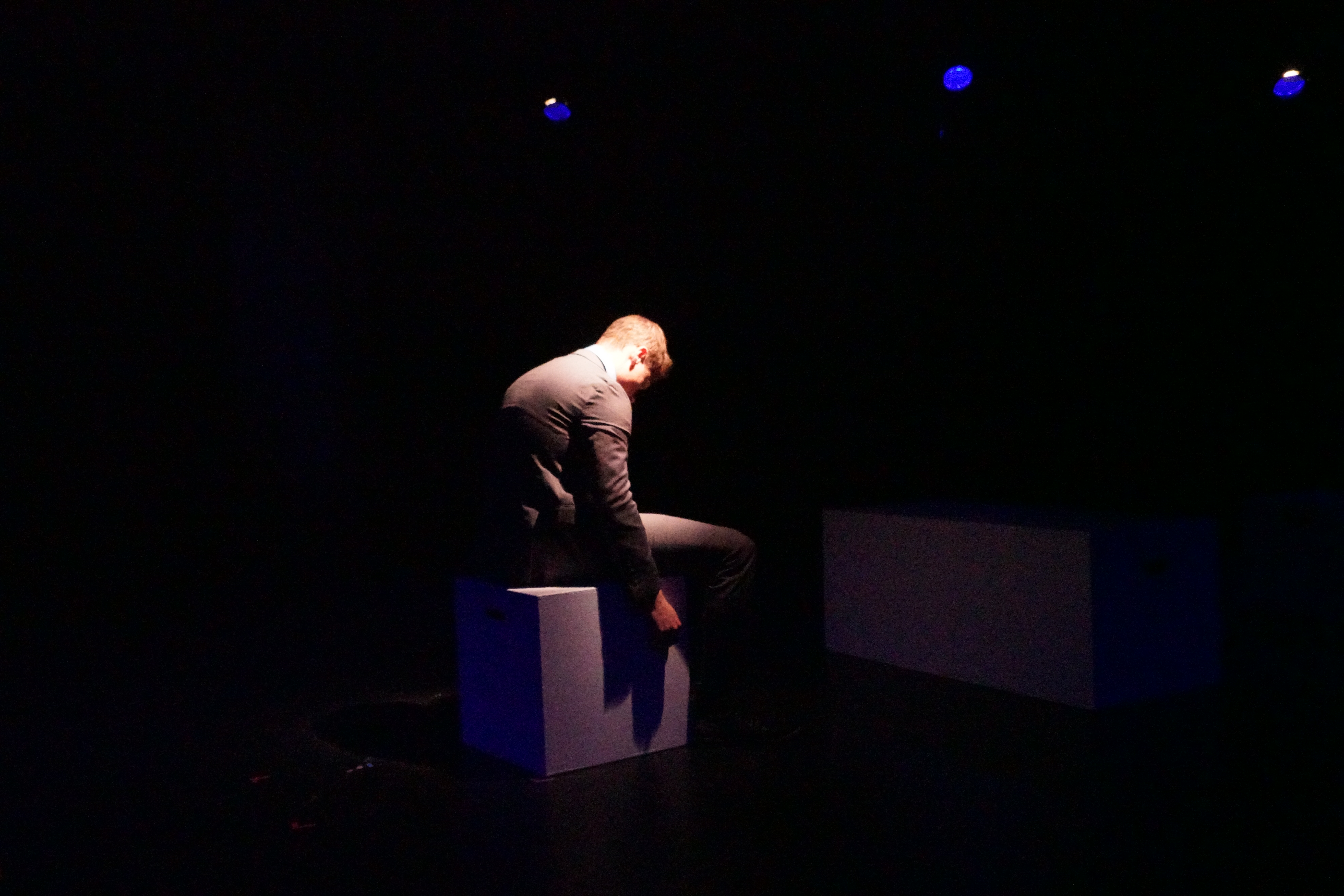 Logan Verlinde as Sam sitting on a block in Second Stage Productions "The Guy Who Didn't Like Musicals"