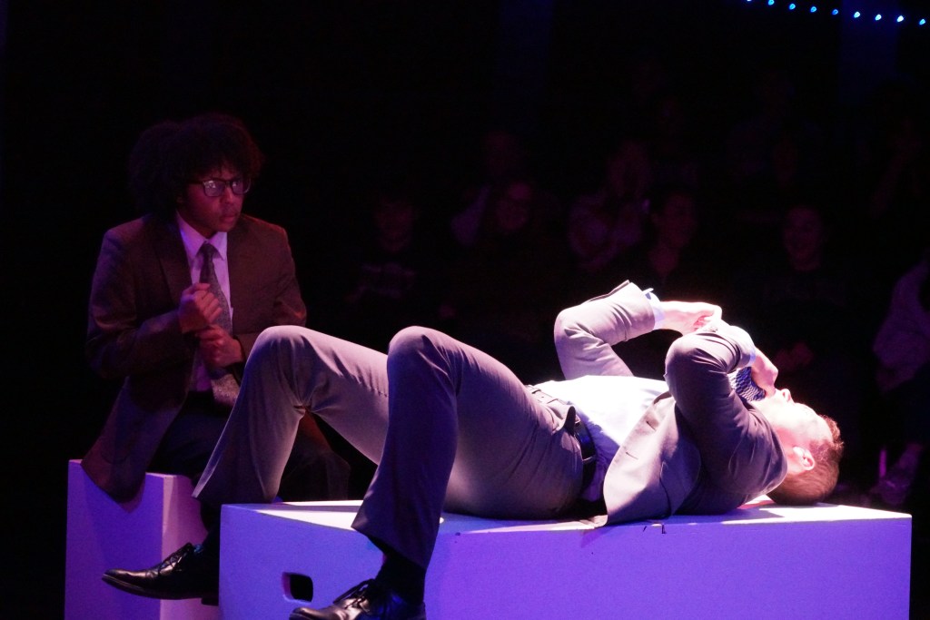 Logan Verlinde as Mr. Davidson laying on block in "What Do You Want Paul" in Second Stage Productions "The Guy Who Didn't Like Musicals"