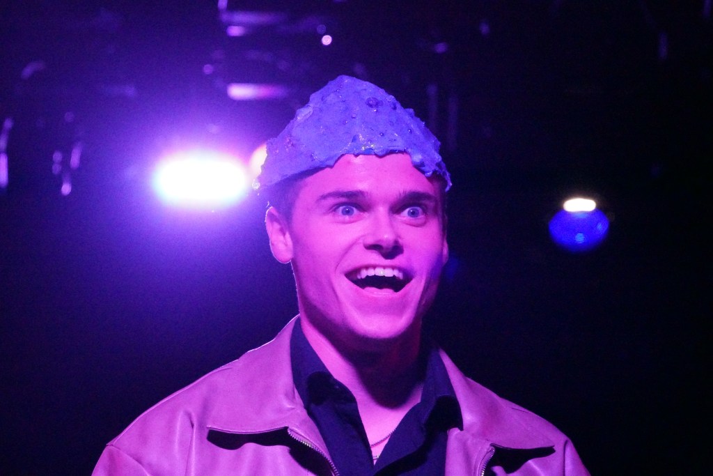 Logan Verlinde as Sam with blue brain showing looking crazy in Second Stage Productions "The Guy Who Didn't Like Musicals"