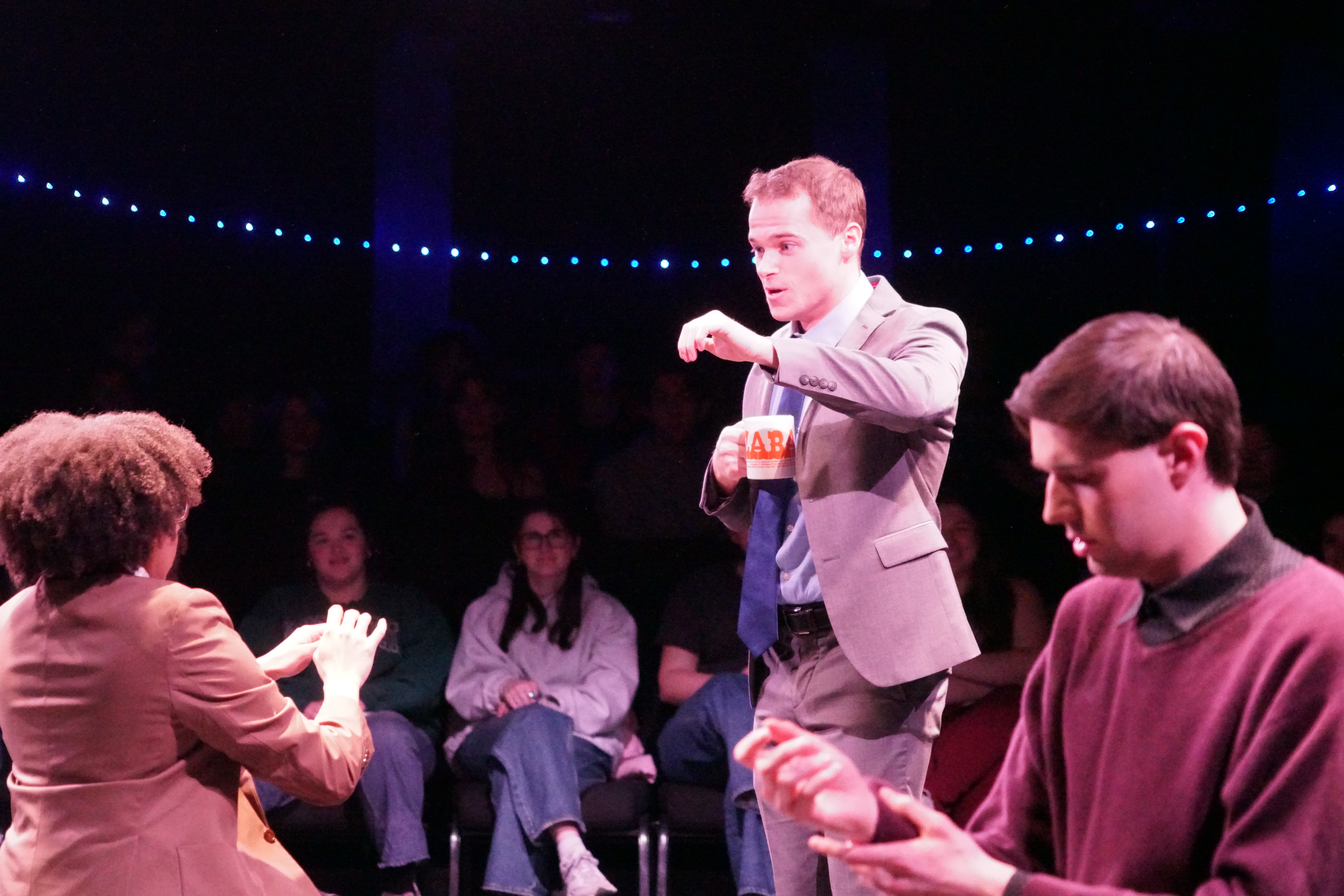 Logan Verlinde as Mr. Davidson checking on August Garrett as Paul with Kyle Jerudsik as Bill and an audience in the background in Second Stage Productions "The Guy Who Didn't Like Musicals"